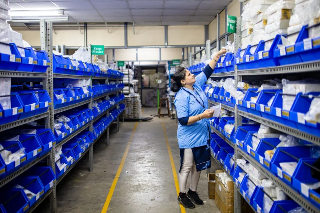 Pasillo de almacén con racks altos donde el ángulo de haz de la luminaria determina la uniformidad